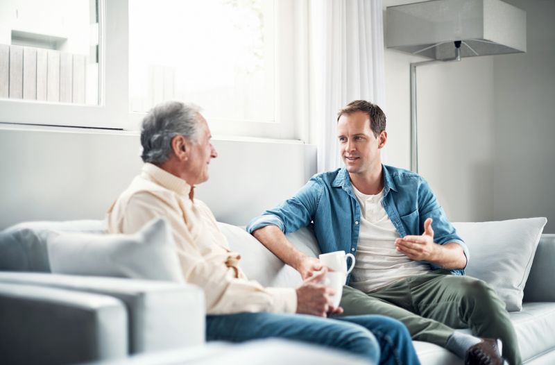Two people sitting in a living room having a conversation.
