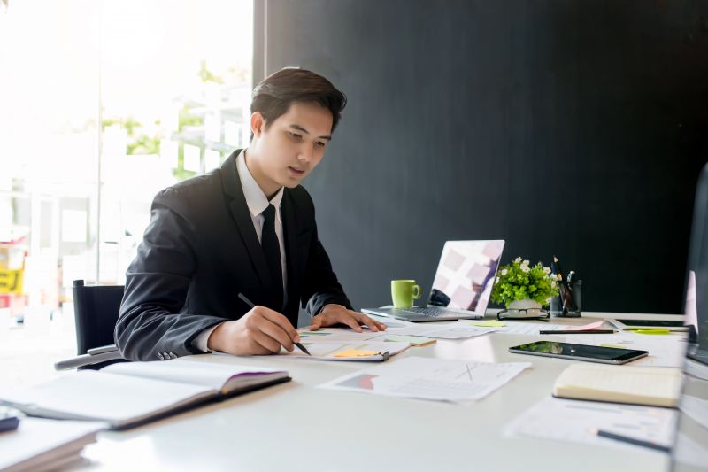 A man sitting at a table writing on a piece of paper